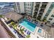 Aerial view of a community pool with lounge chairs and palm trees in a courtyard with the building complex at 1227 E Madison St # 902, Tampa, FL 33602