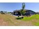Exterior view of home with a spacious backyard, patio, and screened lanai at 12407 Hilltop Farms Dr, Dade City, FL 33525