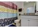 Bright bathroom featuring a granite countertop vanity and a shower with a colorful patterned curtain at 12407 Hilltop Farms Dr, Dade City, FL 33525