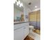 Cozy bathroom featuring a granite vanity top and a shower with a striped curtain at 12407 Hilltop Farms Dr, Dade City, FL 33525