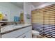 Bathroom with granite countertop vanity and a shower with a colorful striped curtain and modern sink at 12407 Hilltop Farms Dr, Dade City, FL 33525