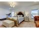 Spacious bedroom with a decorative bed frame, chandelier, and a treadmill for exercise at 12407 Hilltop Farms Dr, Dade City, FL 33525