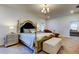 Large bedroom with a decorative bed, a chaise lounge, and soft lighting at 12407 Hilltop Farms Dr, Dade City, FL 33525