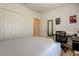 Bright bedroom with desk and closet, featuring neutral bedding and a window, offering comfort and convenience at 12407 Hilltop Farms Dr, Dade City, FL 33525