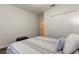 Well-lit bedroom with closet, featuring neutral bedding and a unique patterned stool, offering comfort and style at 12407 Hilltop Farms Dr, Dade City, FL 33525