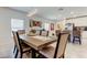 Spacious dining area with table, modern lighting, and open view to the kitchen and living room at 12407 Hilltop Farms Dr, Dade City, FL 33525