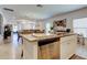 Open concept kitchen with a central island, stainless steel appliances, and seamless flow to the living area at 12407 Hilltop Farms Dr, Dade City, FL 33525