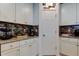 Well-organized kitchen featuring white cabinets and mosaic backsplash at 12407 Hilltop Farms Dr, Dade City, FL 33525