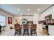 Bright and open kitchen with island seating, granite countertops, stainless appliances and white cabinetry at 12407 Hilltop Farms Dr, Dade City, FL 33525