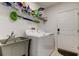 Functional laundry room with washer, dryer, sink, and storage shelves at 12407 Hilltop Farms Dr, Dade City, FL 33525
