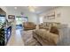 Comfortable living room featuring neutral sofas, sliding glass doors, and natural light at 12407 Hilltop Farms Dr, Dade City, FL 33525