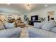 Bright open-concept living space with modern furniture, large TV, and access to kitchen at 12407 Hilltop Farms Dr, Dade City, FL 33525