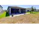 View of the back patio with pavers and a screened enclosure, perfect for outdoor relaxation and entertaining at 12407 Hilltop Farms Dr, Dade City, FL 33525