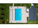 Aerial view of a pristine community pool with ample lounge seating, perfect for summer relaxation at 12407 Hilltop Farms Dr, Dade City, FL 33525