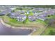 Aerial view featuring houses surrounding a lake and green spaces in the community at 12905 Brookside Moss Dr, Riverview, FL 33579