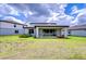 Back exterior of the home featuring an extended covered patio and green grass at 12905 Brookside Moss Dr, Riverview, FL 33579