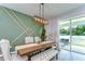 Dining room with a large table, bench seating, decorative wall accents and sliding doors at 12905 Brookside Moss Dr, Riverview, FL 33579