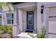 Close-up of the front entrance featuring a blue door, sidelight, and decorative plants at 12905 Brookside Moss Dr, Riverview, FL 33579