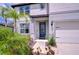 Welcoming front entrance with a blue door, lush landscaping and a two-car garage at 12905 Brookside Moss Dr, Riverview, FL 33579