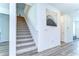 Carpeted staircase featuring white walls and wood floors at 12905 Brookside Moss Dr, Riverview, FL 33579