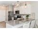 Modern kitchen features granite countertops, stainless steel appliances, and stylish pendant lighting over breakfast bar at 13084 Stillmont Pl, Tampa, FL 33624
