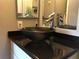 Bathroom featuring a unique dark vessel sink atop a black granite vanity top at 1400 Gandy N Blvd # 708, St Petersburg, FL 33702