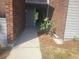 Building entrance framed with brick and grey siding, with flower accent at 1400 Gandy N Blvd # 708, St Petersburg, FL 33702