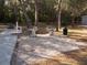 Community grilling area with two grills, gravel, a trash can and a sidewalk to other amenities at 1400 Gandy N Blvd # 708, St Petersburg, FL 33702