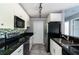 Bright kitchen featuring white cabinets, black countertops, and stainless-steel appliances at 1400 Gandy N Blvd # 708, St Petersburg, FL 33702