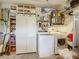 Functional laundry room includes washer and dryer, storage cabinets, shelving, and a refrigerator at 1542 Rebecca Ln, Dunedin, FL 34698