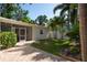 Outdoor space featuring a paved patio, lush lawn, palm trees, and a screened-in porch at 1606 S Arrawana Ave, Tampa, FL 33629