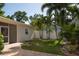 Outdoor space featuring a paved patio, lush lawn, palm trees, and a screened-in porch at 1606 S Arrawana Ave, Tampa, FL 33629