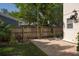 Brick patio with a wooden fence, green plants, and partial view of the house at 1606 S Arrawana Ave, Tampa, FL 33629