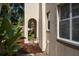 Exterior side view with covered entryway and lush tropical plants at 1606 S Arrawana Ave, Tampa, FL 33629