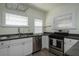 Kitchen with stainless steel appliances, gray countertops and white cabinetry at 1606 S Arrawana Ave, Tampa, FL 33629