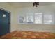Bright living room featuring charming tile floors, a large window with white shutters, and a blue door at 1606 S Arrawana Ave, Tampa, FL 33629