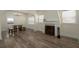 Open-concept living space with wood-look floors, a fireplace, and a dining area with unique seating at 1606 S Arrawana Ave, Tampa, FL 33629