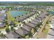 Aerial view of a lakefront residential community featuring single-Gathering homes, mature trees, and a large pond at 16313 Treasure Point Dr, Wimauma, FL 33598