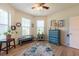 Versatile bedroom with wood laminate floors, a blue dresser, and natural light from multiple windows at 16313 Treasure Point Dr, Wimauma, FL 33598