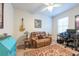 Bedroom with comfortable seating area, ceiling fan, and bright natural light at 16313 Treasure Point Dr, Wimauma, FL 33598
