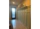 Inviting entryway featuring decorative wall paneling, a shelf with hooks, and tile flooring at 16313 Treasure Point Dr, Wimauma, FL 33598