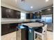 Modern kitchen featuring dark cabinets, stainless steel appliances, granite countertops, and an island with seating at 16313 Treasure Point Dr, Wimauma, FL 33598