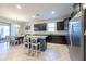Modern kitchen featuring dark cabinets, stainless steel appliances, granite countertops, and an island with seating at 16313 Treasure Point Dr, Wimauma, FL 33598