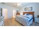 Bright bedroom with a wooden headboard, neutral bedding, and a glimpse into the en suite bathroom at 16313 Treasure Point Dr, Wimauma, FL 33598