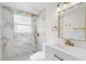 Modern bathroom featuring white marble tile, gold fixtures, and a sleek vanity with sink at 16411 Lake Byrd Dr, Tampa, FL 33618
