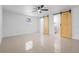 Bedroom with a ceiling fan, tile floors, and sliding wood doors to the closet and bathroom at 16411 Lake Byrd Dr, Tampa, FL 33618
