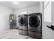 Modern laundry room equipped with stainless steel washer, dryer, and a water heater at 16411 Lake Byrd Dr, Tampa, FL 33618