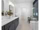 Bathroom featuring double vanity sinks, glass shower, and linen closet at 17093 Moonflower Dr, Venice, FL 34293