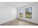 Bedroom featuring two large windows, plenty of natural light, and modern gray wood-look flooring at 17093 Moonflower Dr, Venice, FL 34293