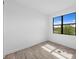 A light-filled bedroom with wood-look tile flooring and a large window overlooking the outdoors at 17093 Moonflower Dr, Venice, FL 34293